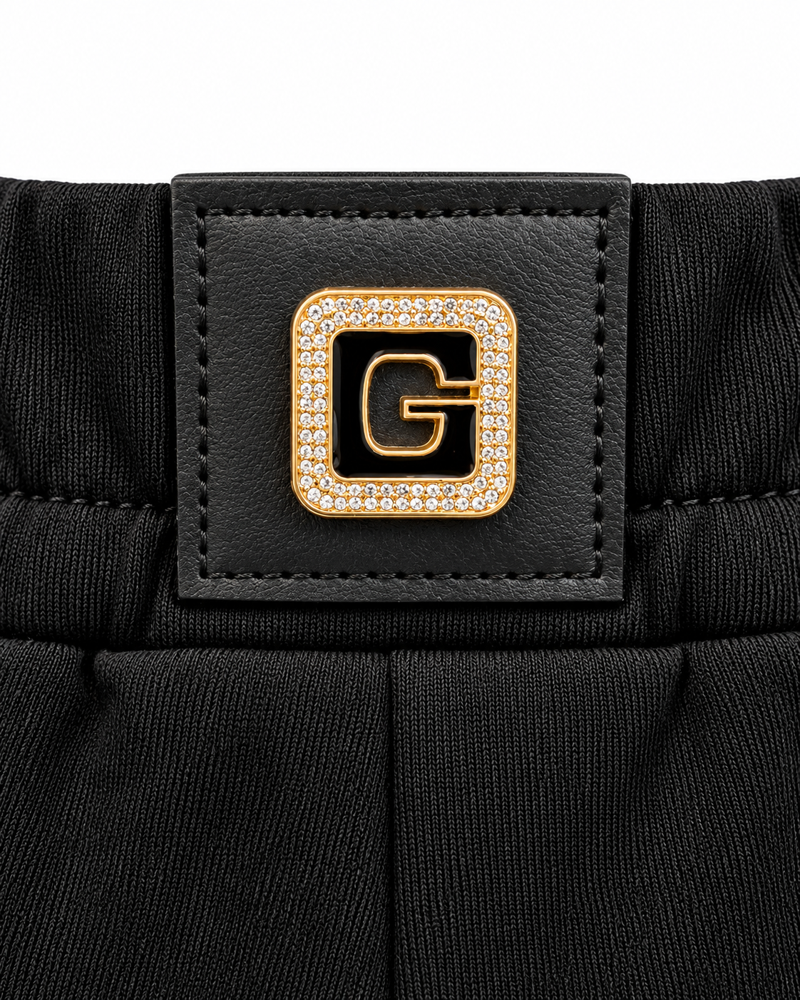 Black jogger pants with crystal heart detail and gold G logo patch